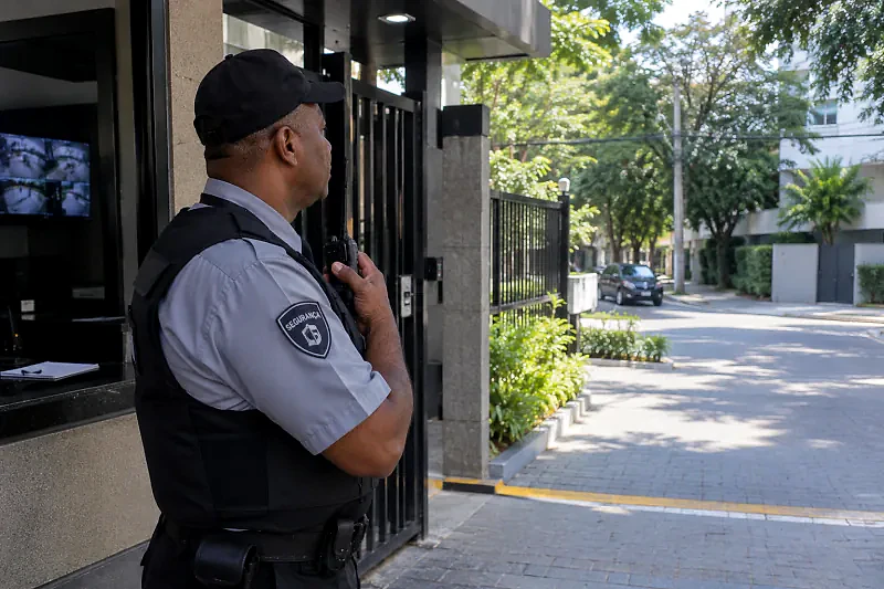 Porteiro com rádio controlando a entrada de um condomínio